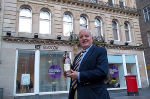 Dram good show……John pictured outside the Teacher’s building holding, appropriately, a bottle of Teacher’s whisky.